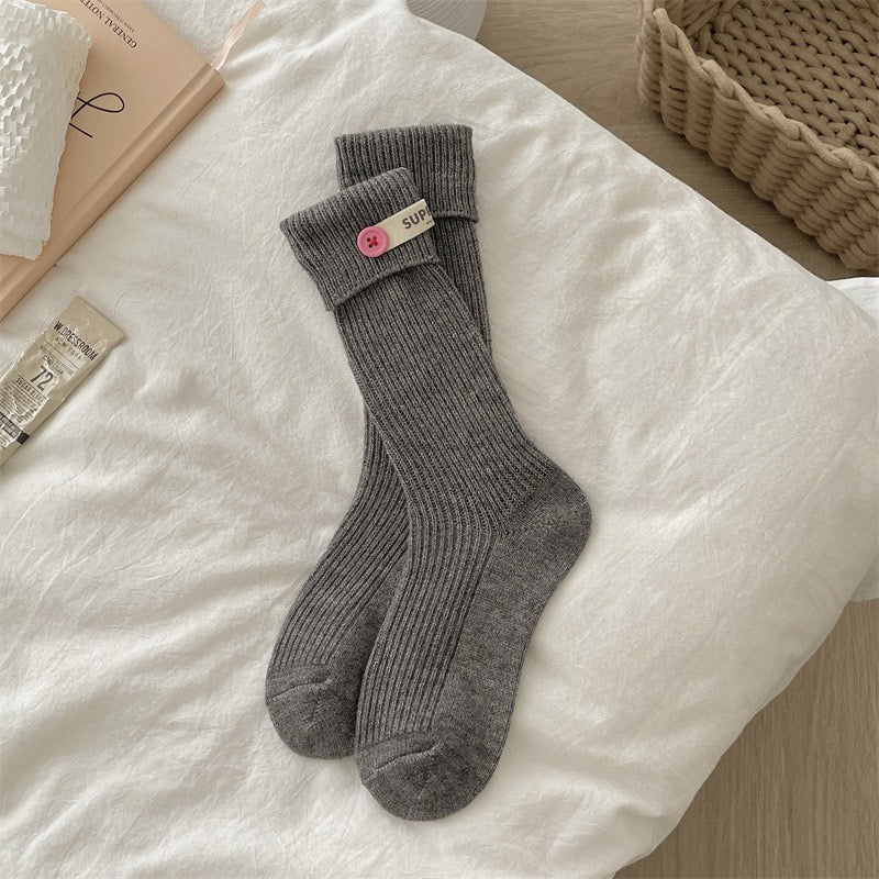 ChicToes grey crew socks, with a pink button at the ankle area