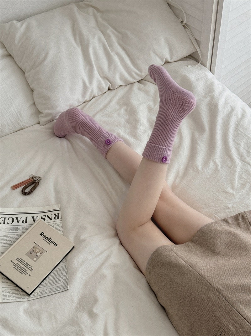 Model wearing ChicToes light purple button socks in bed
