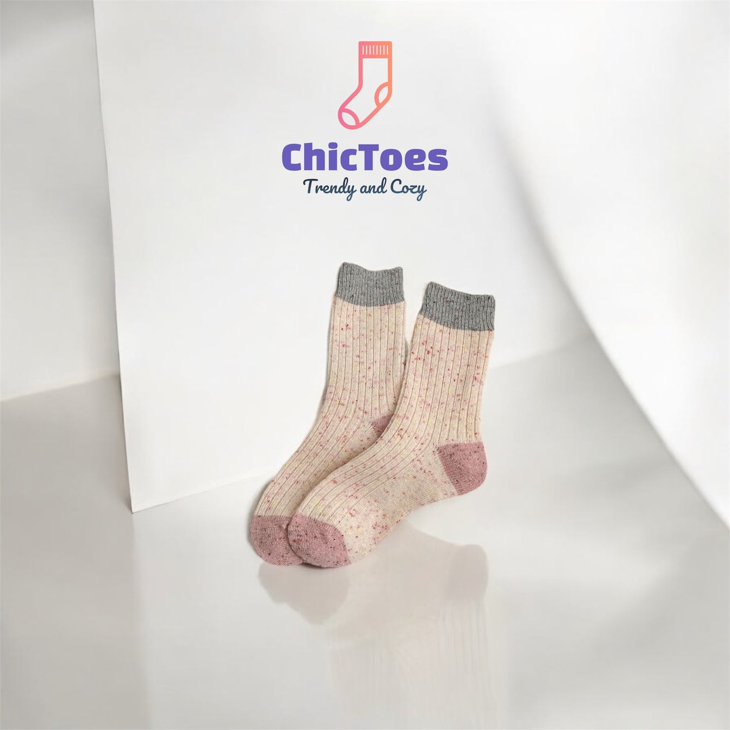 A soft pink ribbed sock with speckled patterns and a muted pink heel and toe, resembling a sweet strawberry cream cheese treat.